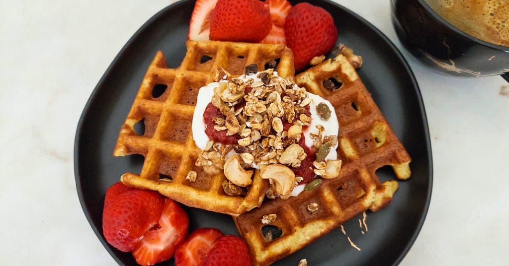 Waffles de coco com topping de queijo quark, doce de morango, granola e morangos. Deliciosas ideias do dia Waffles de coco com topping de queijo quark, doce de morango, granola e morangos.