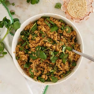 Quinoa com pesto de tomate seco servida em taça branca para acompanhamento