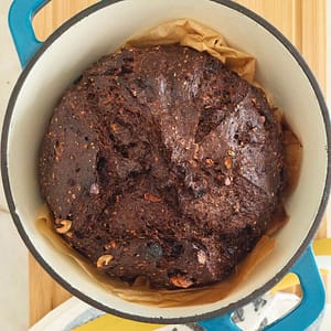 Pão de alfarroba e aveia dentro do tacho de ferro fundido com tampa no forno