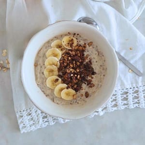 Papas de Aveia Cremosas com Banana e Skyr servidas numa taça e toppings