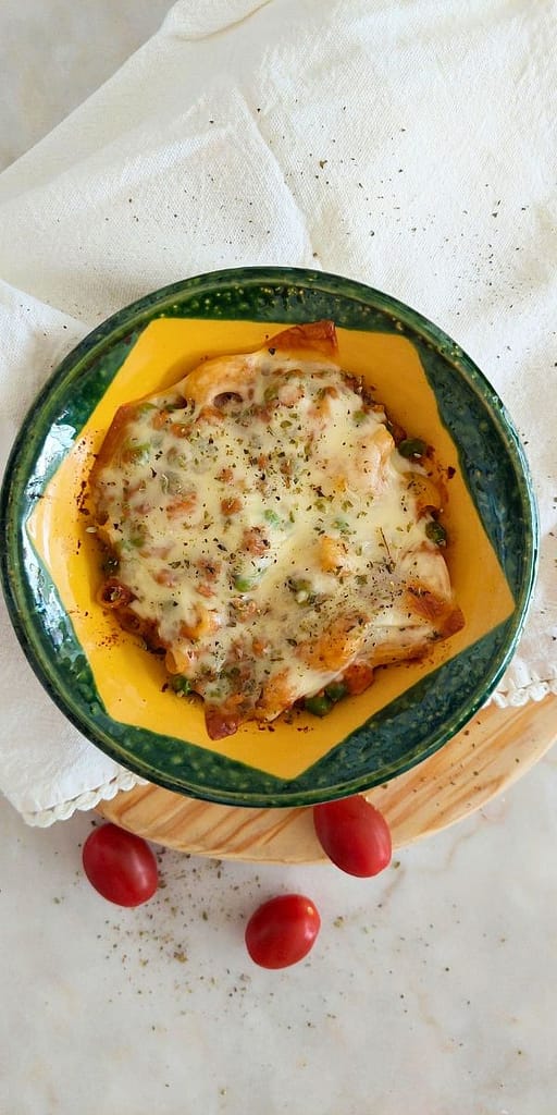 Travessa de gratinado com carne picada e ervilhas servido à mesa