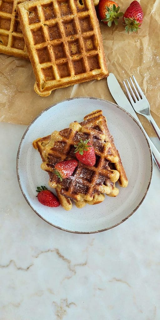 Waffles integrais sem açúcar servidas com morangos frescos e mel