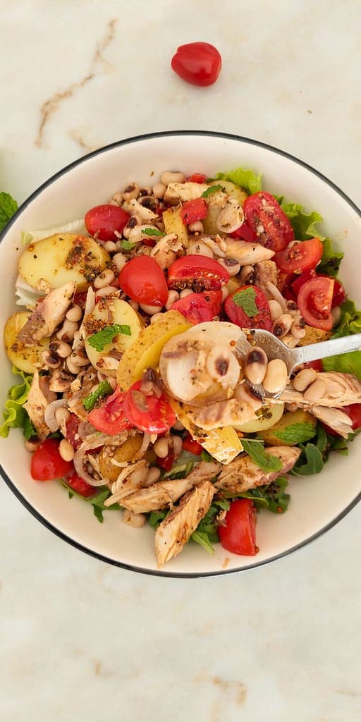Close-up da salada com batata, cavala, tomate cherry e pimento vermelho