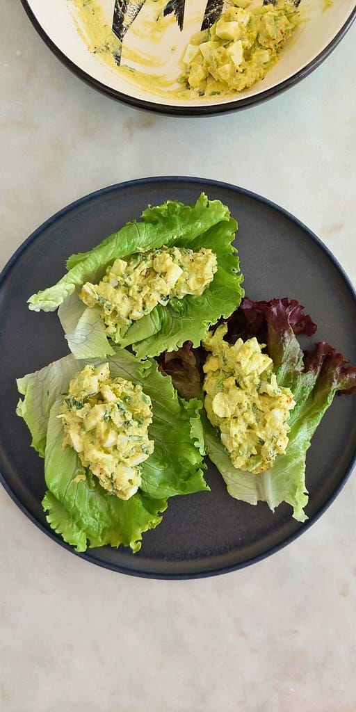 Close up de Salada de abacate com ovo cozido e ervas aromáticas servida em wraps de alface