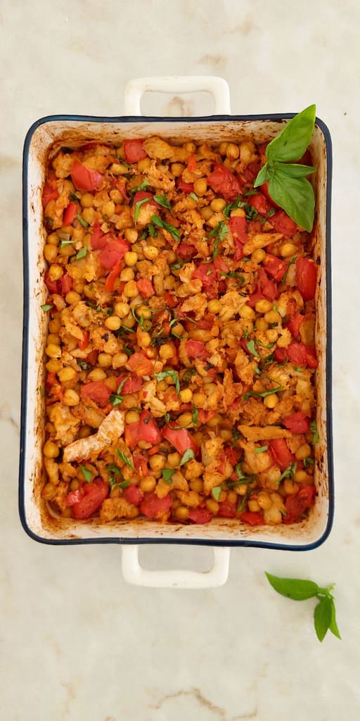 Close-up do bacalhau desfiado dourado com legumes no forno