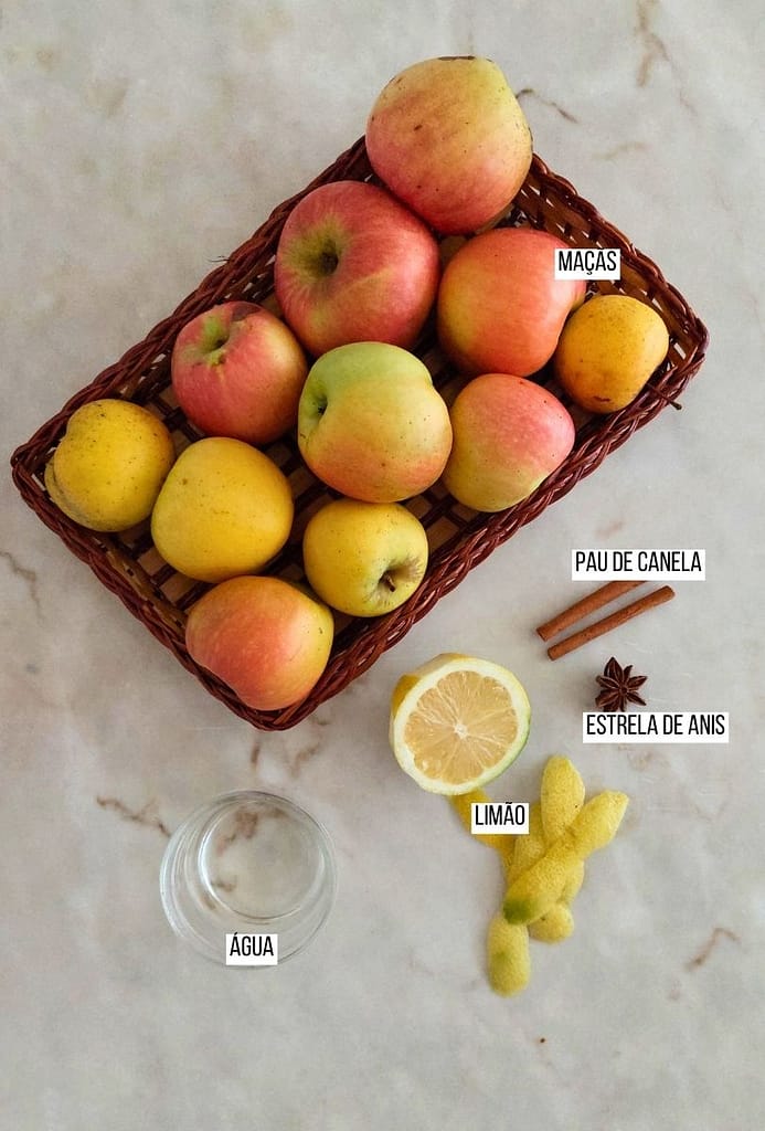 Ingredientes dispostos na bancada, maçã, pau de canela, limão, água e estrela de anis.