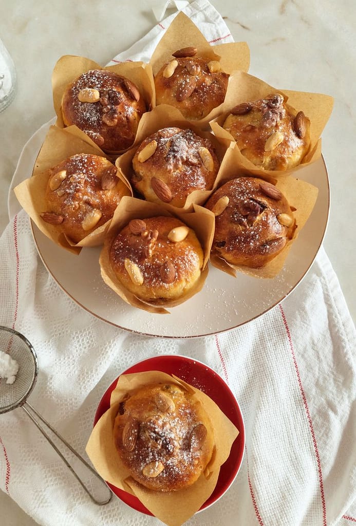 Muffins bolo rainha servidos num prato branco e polvilhados com açucar em pó