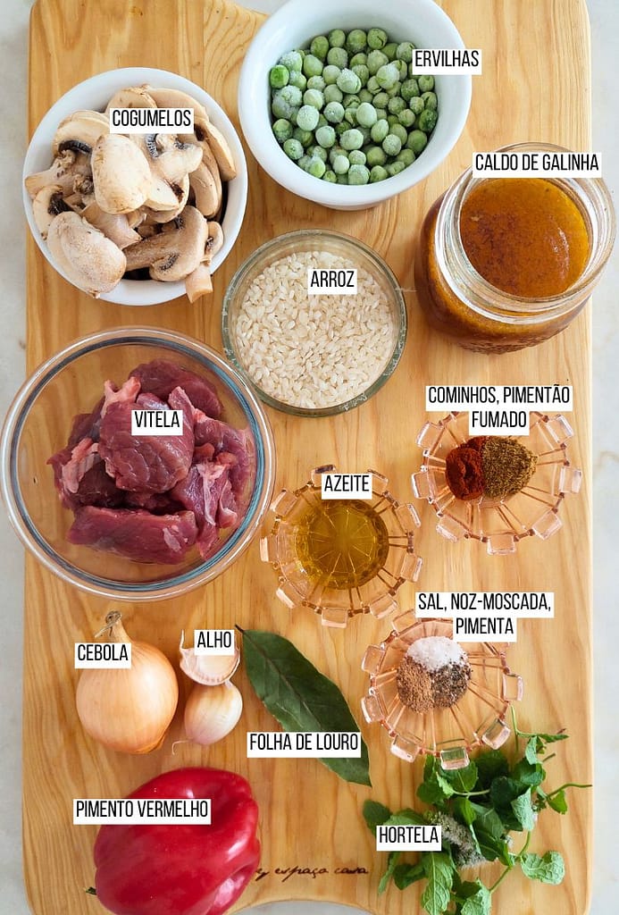Ingredientes dispostos na pedra branca, carne, ervilhas arroz, cogumelos e especiarias