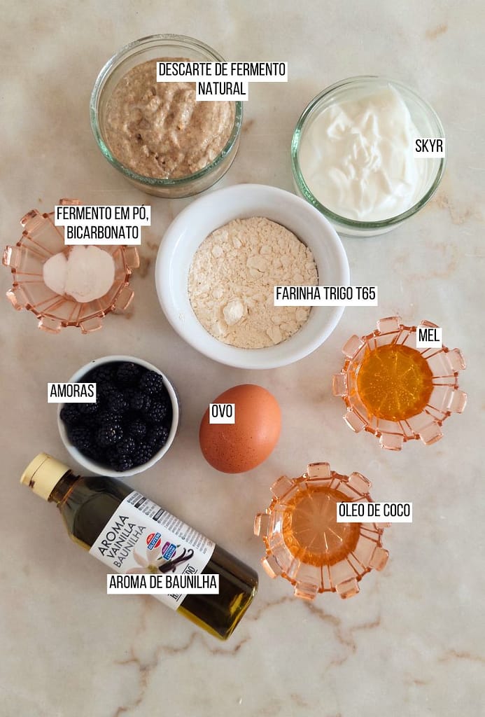 Ingredientes dispostos na pedra descarte, farinha, mel, ovo, amoras, baunilha