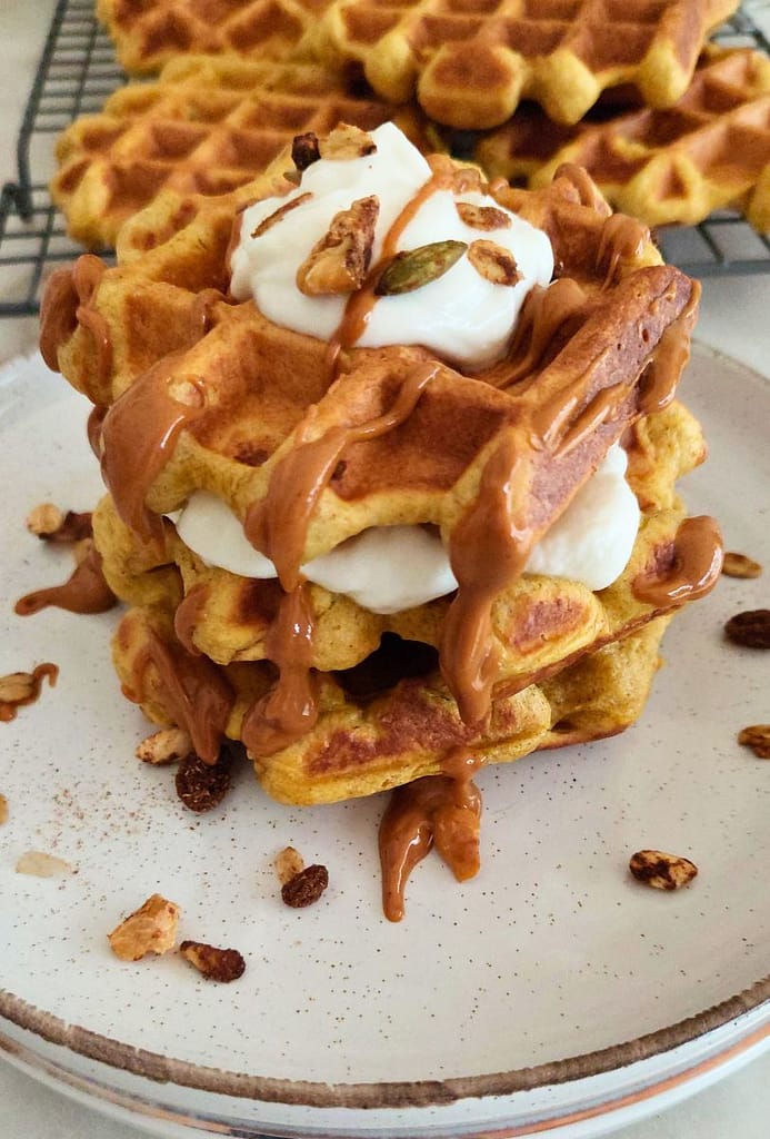close up Waffle de abóbora servido num prato bonito com acompanhamentos (fruta, mel, etc.)